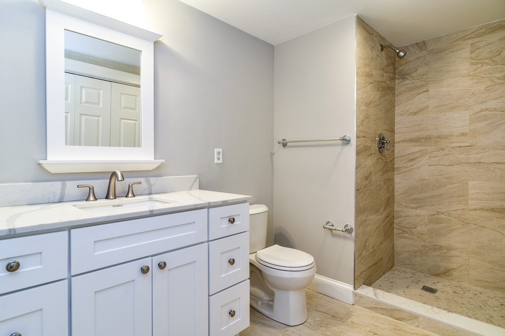 8 Everett Street Sherborn, MA 01770 - Photo 19 of 25 a bathroom with a granite countertop sink toilet a mirror a vanity and shower