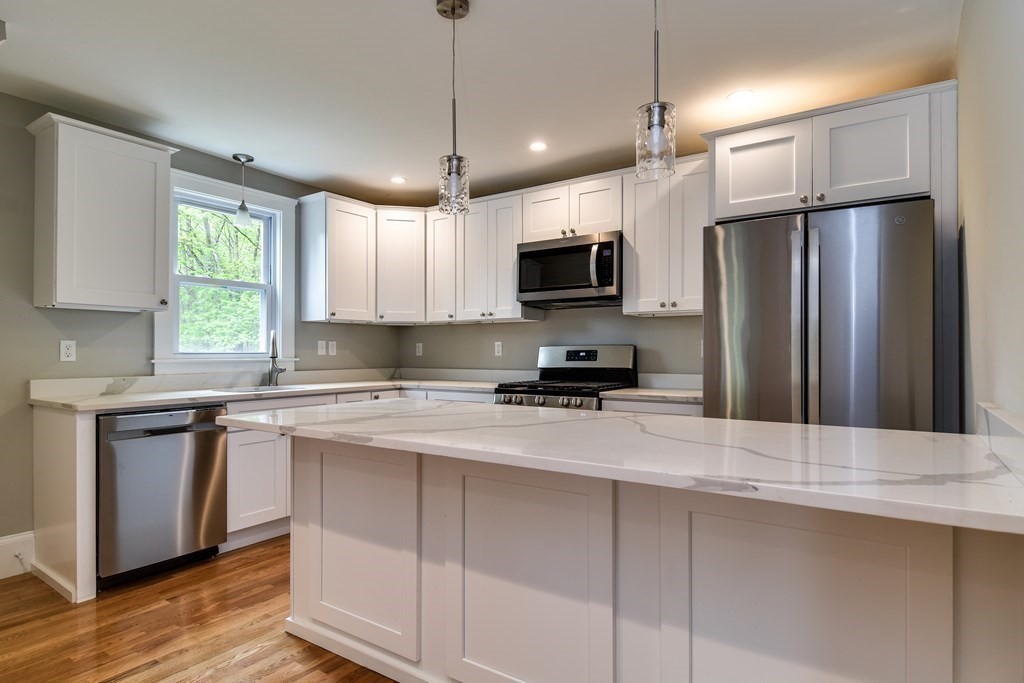 8 Everett Street Sherborn, MA 01770 - Photo 9 of 25 a kitchen with kitchen island a counter space a sink appliances and cabinets