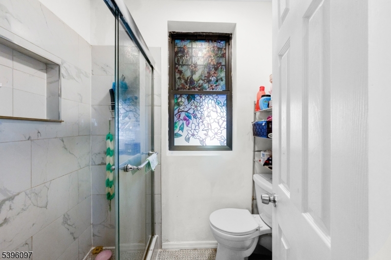 113 Second Street Elizabeth Port, NJ 07206 - Photo 9 of 34 a bathroom with a toilet and a shower curtain
