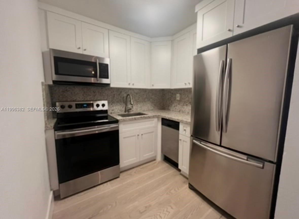 a kitchen with stainless steel appliances a refrigerator stove and microwave