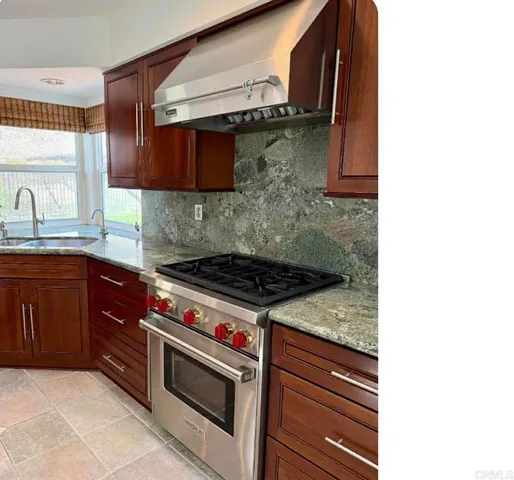 a kitchen with granite countertop a stove and a sink