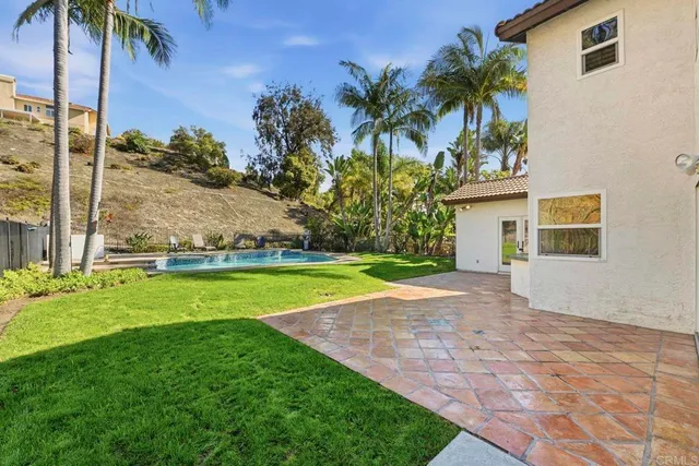 a view of backyard with swimming pool and outdoor seating