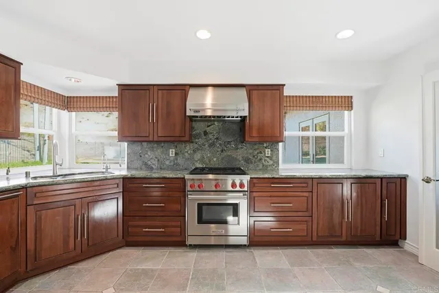a kitchen with granite countertop stainless steel appliances and wooden cabinets