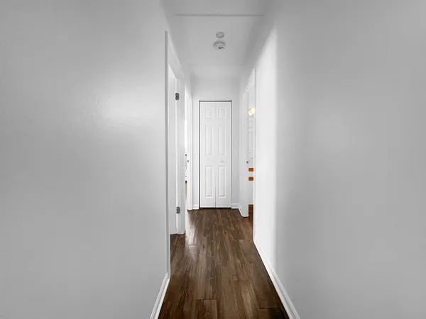 a view of a hallway with wooden floor
