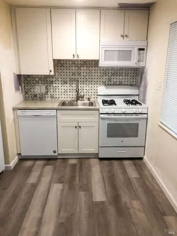 a kitchen with cabinets appliances and a wooden floor