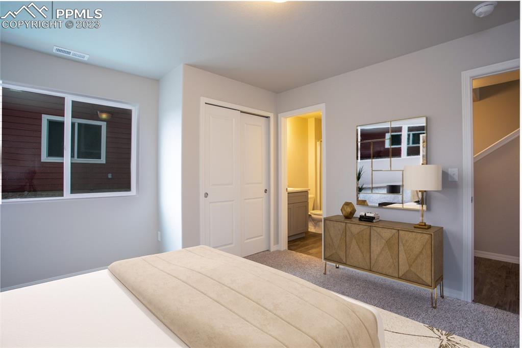 4447 Samaritan Loop Colorado Springs, CO 80916 - Photo 4 of 17 a bedroom with a bed and glass windows