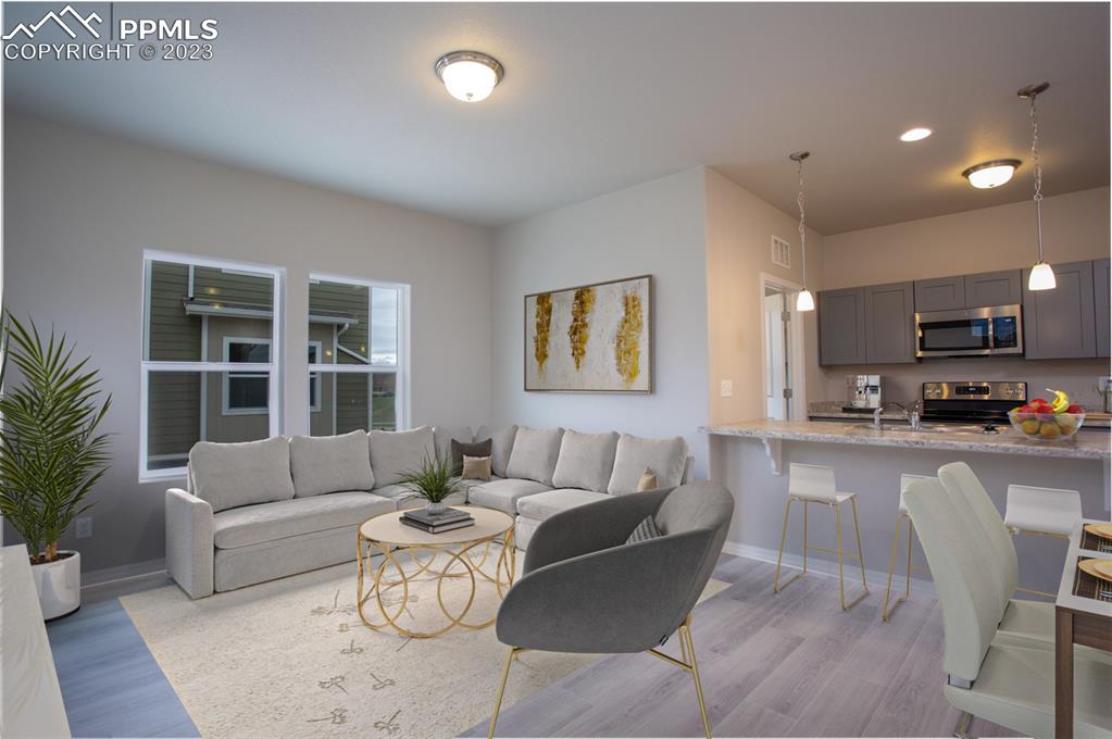 4447 Samaritan Loop Colorado Springs, CO 80916 - Photo 7 of 17 a living room with furniture a large window and a table
