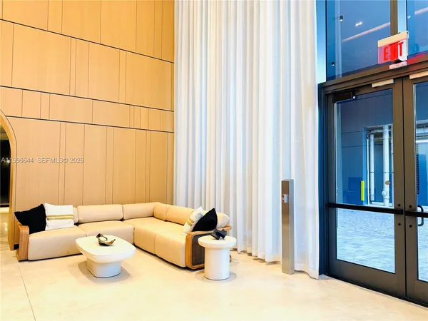 a view of a hallway with white walls and stairs