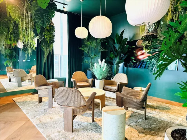a living room with furniture flowerpot and a chandelier