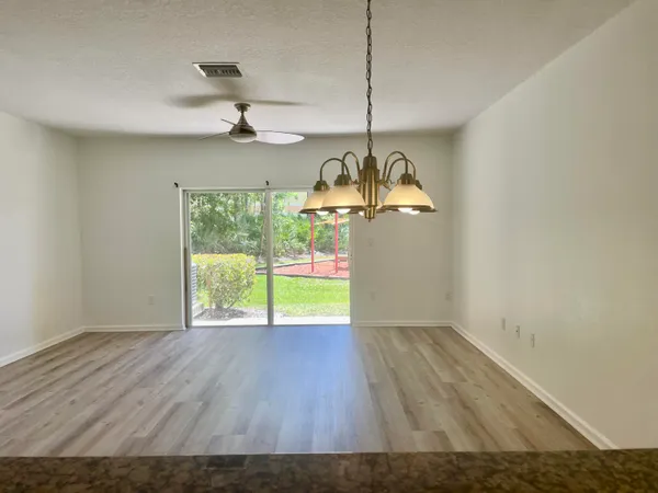 a view of an empty room with a window and chandelier