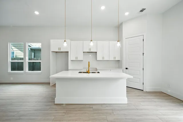 a kitchen with kitchen island a sink stainless steel appliances and cabinets