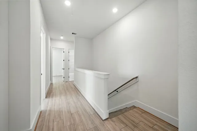 a view of a hallway with wooden floor