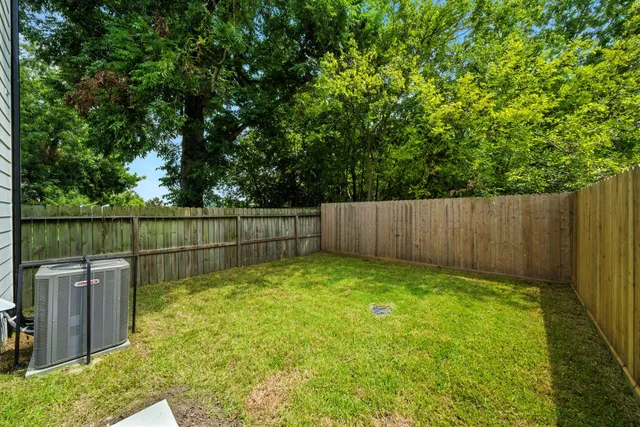 a view of backyard with wooden fence