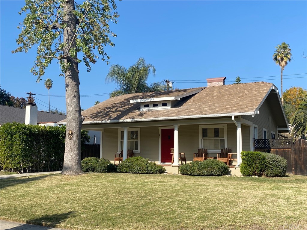 a view of a house with a yard and potted plants