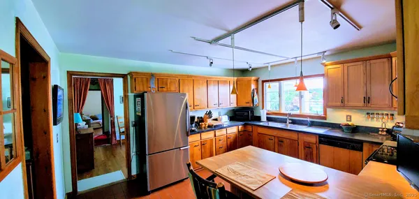 a kitchen with stainless steel appliances granite countertop a refrigerator a sink and wooden cabinets