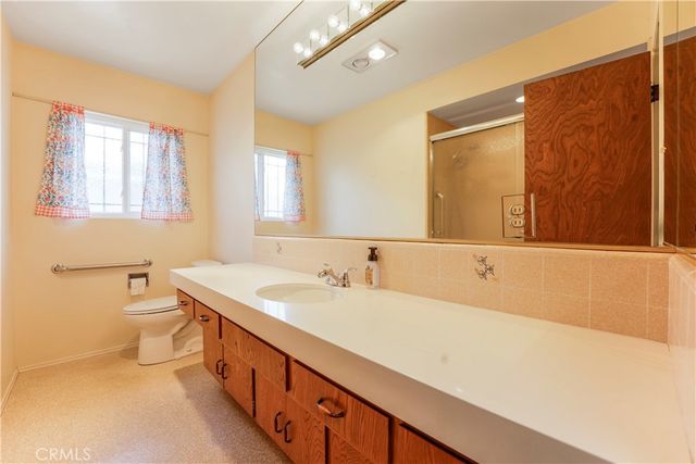 a view of an empty room with closet and windows