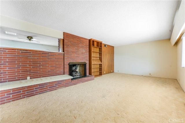 an empty room with a fireplace and window
