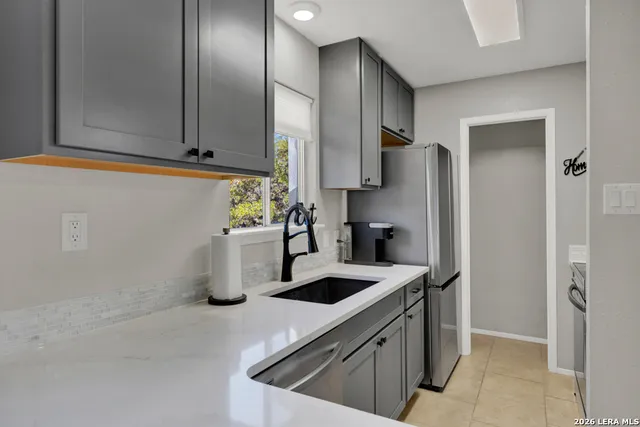a kitchen with stainless steel appliances granite countertop a sink a refrigerator and a stove