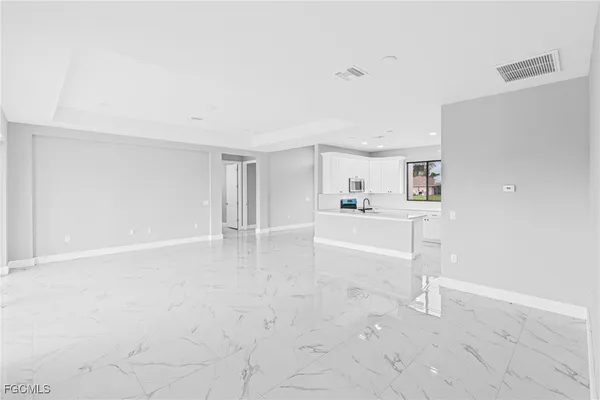 a view of a kitchen with refrigerator and white cabinets