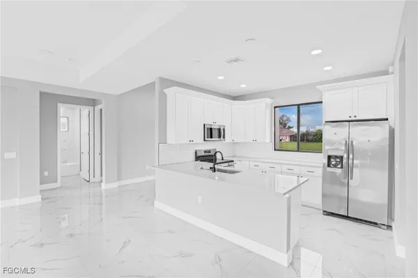 a kitchen with stainless steel appliances a refrigerator sink and microwave