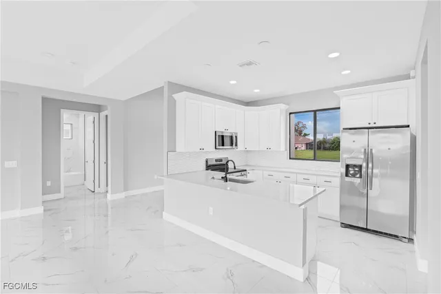 a kitchen with stainless steel appliances a refrigerator sink and microwave