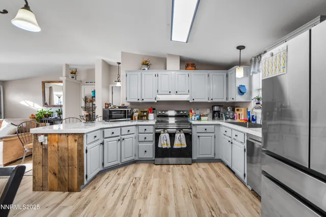 a kitchen with white cabinets stainless steel appliances and a refrigerator