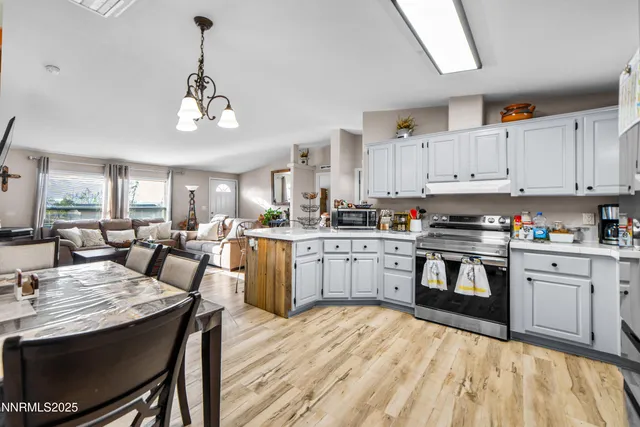 a open kitchen with stainless steel appliances granite countertop a stove dining table chairs and granite counter tops