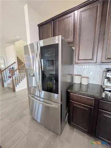 a kitchen with granite countertop a refrigerator and a stove