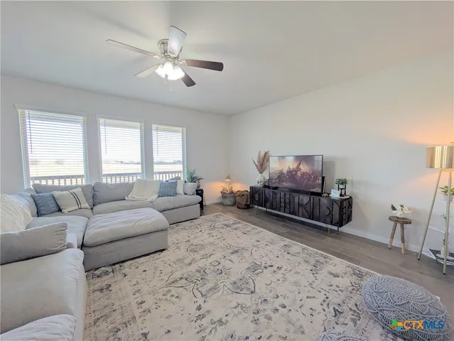 a living room with furniture ceiling fan and a window