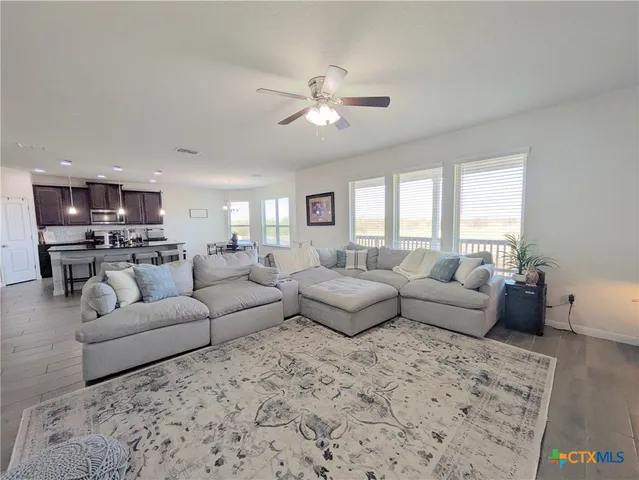 a living room with furniture and a view of kitchen