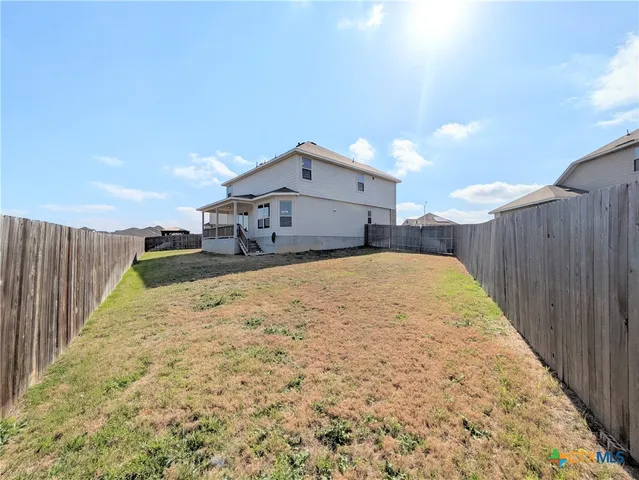 a view of a house with a wooden fence