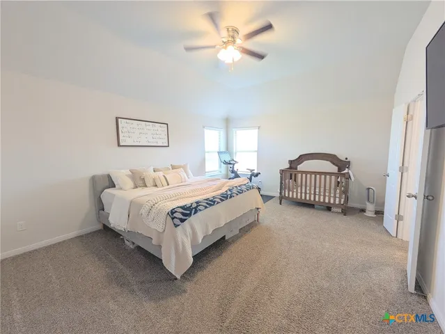a bedroom with a bed and a ceiling fan with window