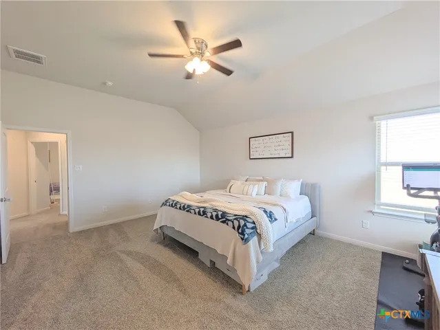 a spacious bedroom with a bed and a window