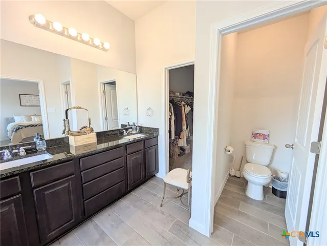 a bathroom with a sink a toilet and a mirror