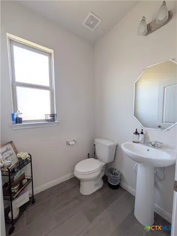 a bathroom with a toilet sink and mirror