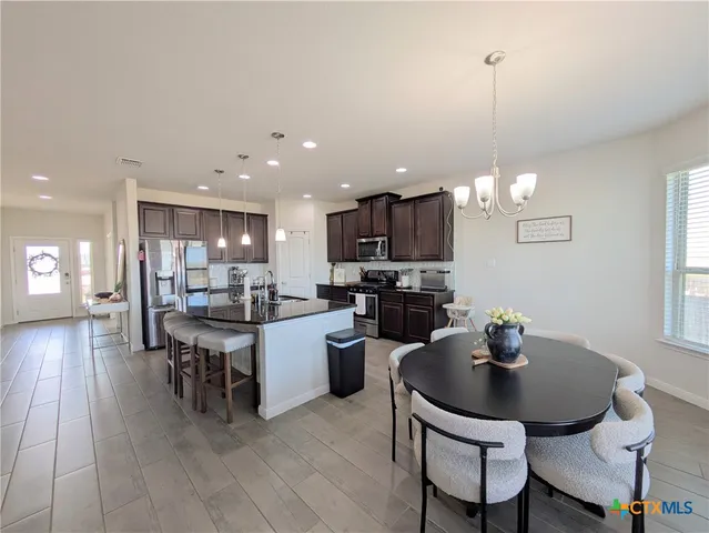 a kitchen with a dining table chairs and microwave