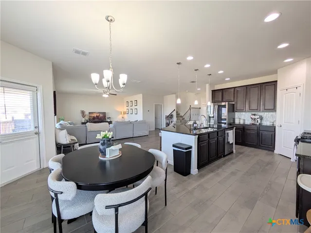 a kitchen with kitchen island a dining table and chairs