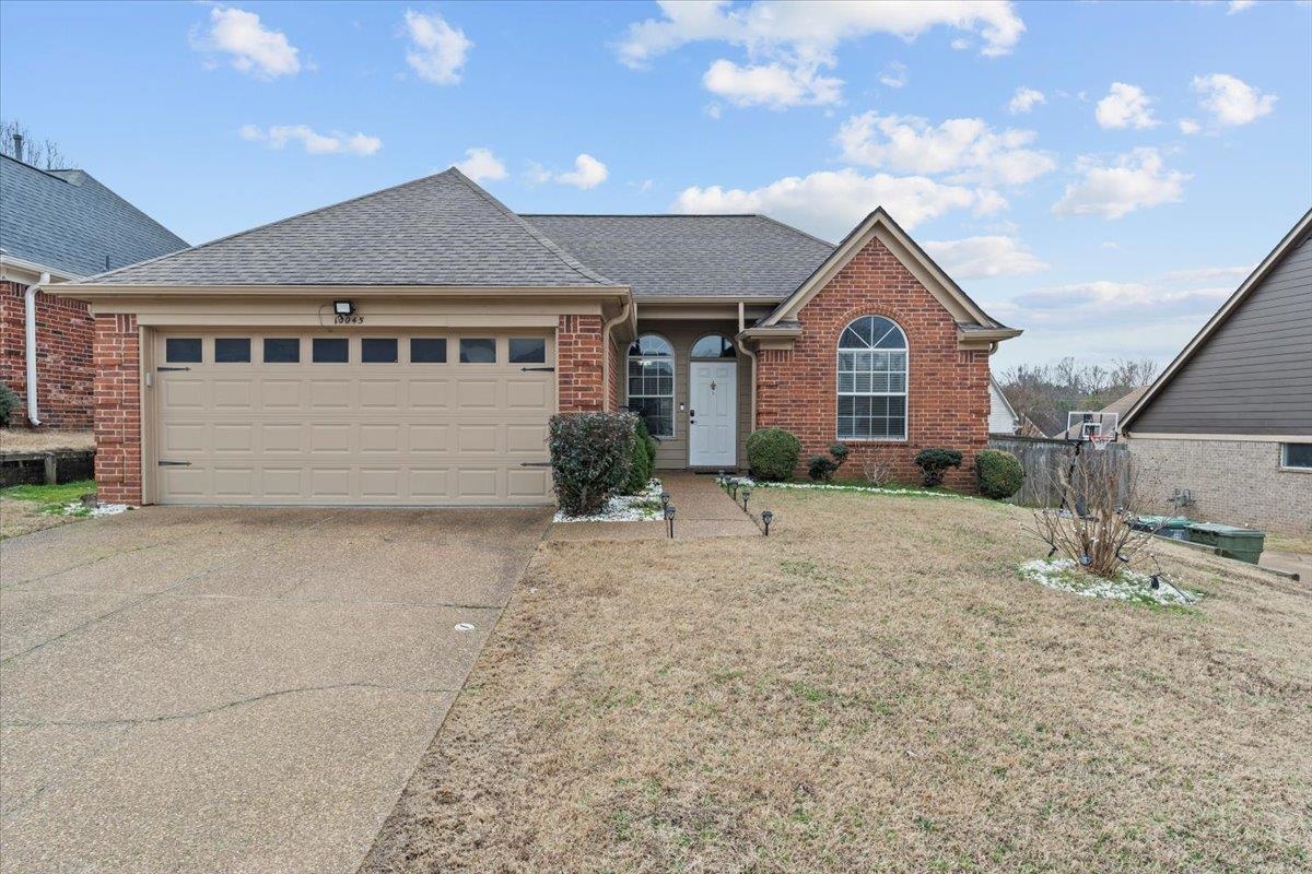 10045 Notting Hill Road Memphis, TN 38016 - Photo 1 of 17 Single story home with a shingled roof, concrete driveway, an attached garage, a front lawn, and brick siding