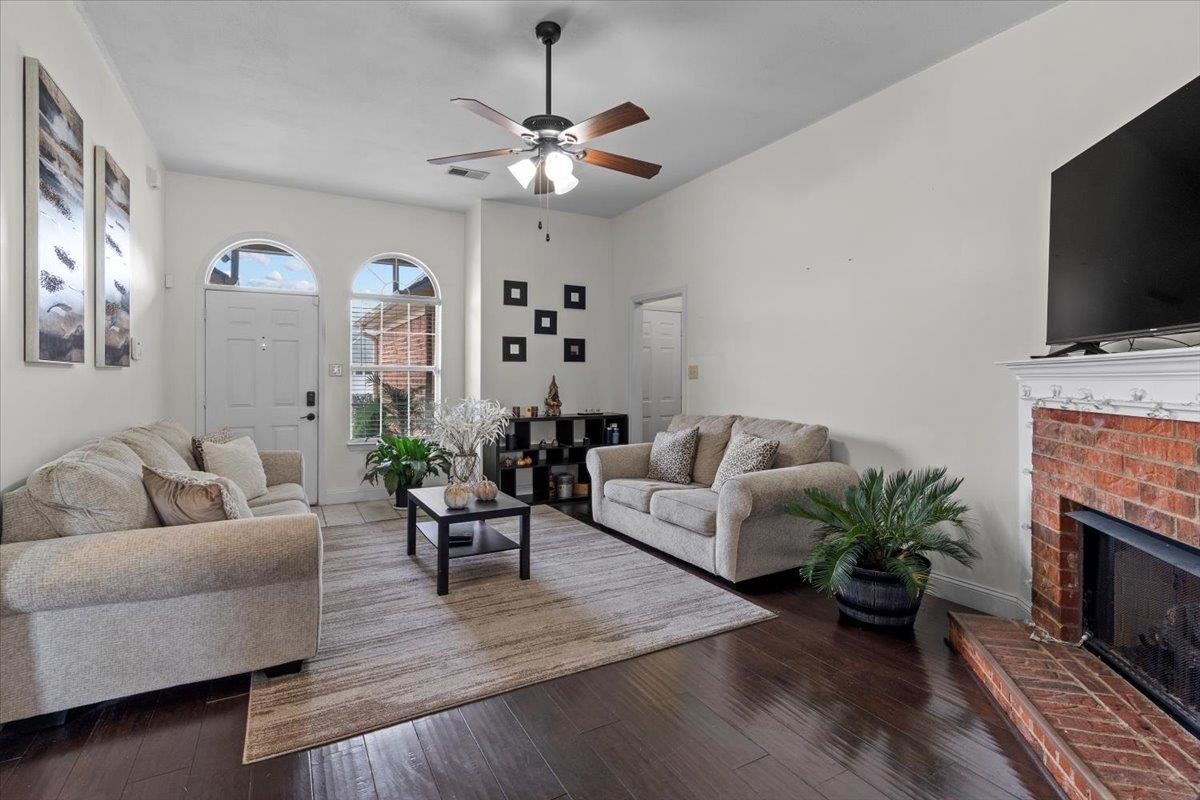 10045 Notting Hill Road Memphis, TN 38016 - Photo 3 of 17 Living room with ceiling fan, wood-type flooring, and a brick fireplace