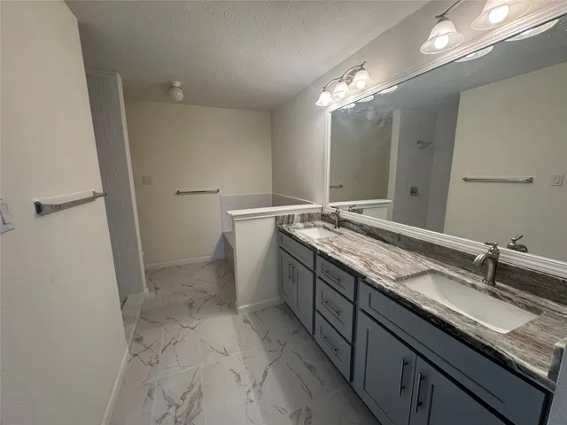 a bathroom with a granite countertop sink a toilet and a mirror
