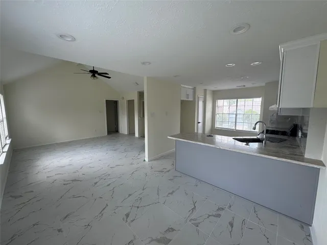 a large living room with stainless steel appliances granite countertop a couch and a stove top oven