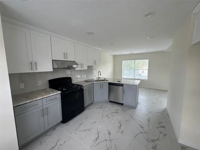 a kitchen with a stove top oven sink and cabinets
