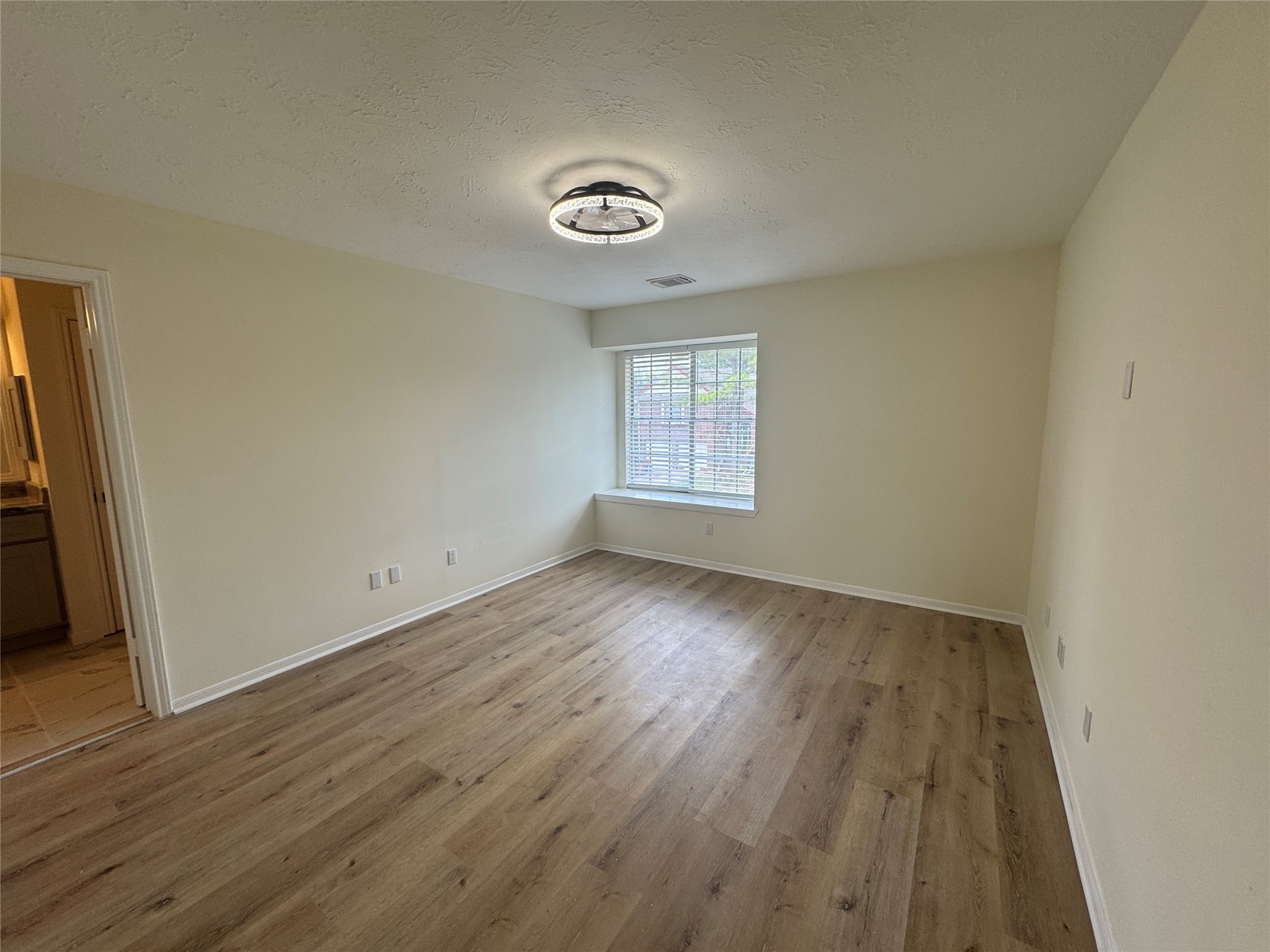 12827 Waybridge Street Sugar Land, TX 77478 - Photo 9 of 23 an empty room with wooden floor and windows