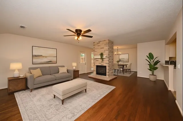 a living room with furniture fireplace and wooden floor