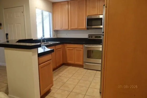 a kitchen with stainless steel appliances granite countertop a stove a sink and a refrigerator