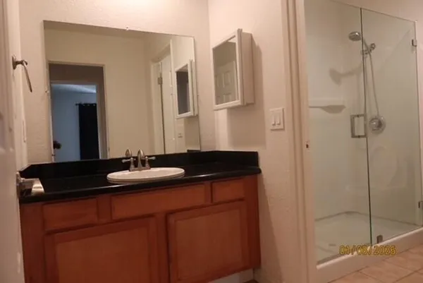 a bathroom with a granite countertop sink and mirror