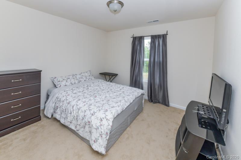 6565 Paw Village Road Charlotte, NC 28214 - Photo 13 of 26 a bedroom with a bed and a mirror