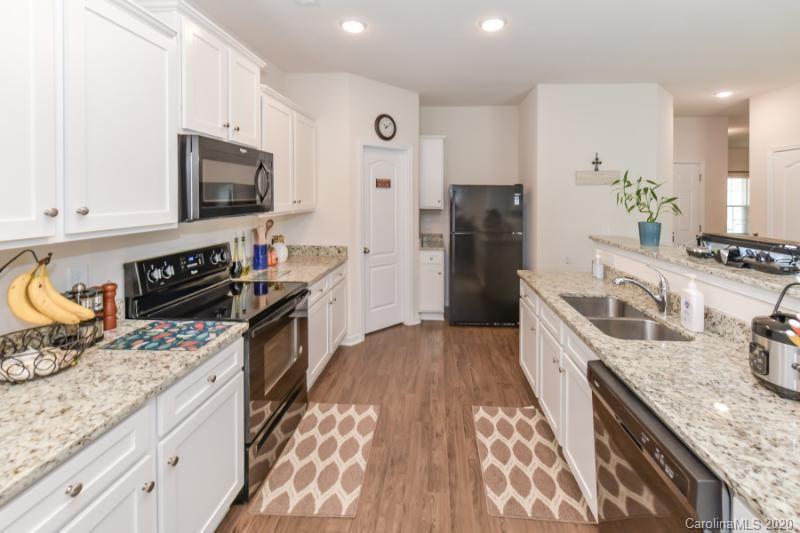 6565 Paw Village Road Charlotte, NC 28214 - Photo 4 of 26 a kitchen with granite countertop a sink stove and refrigerator
