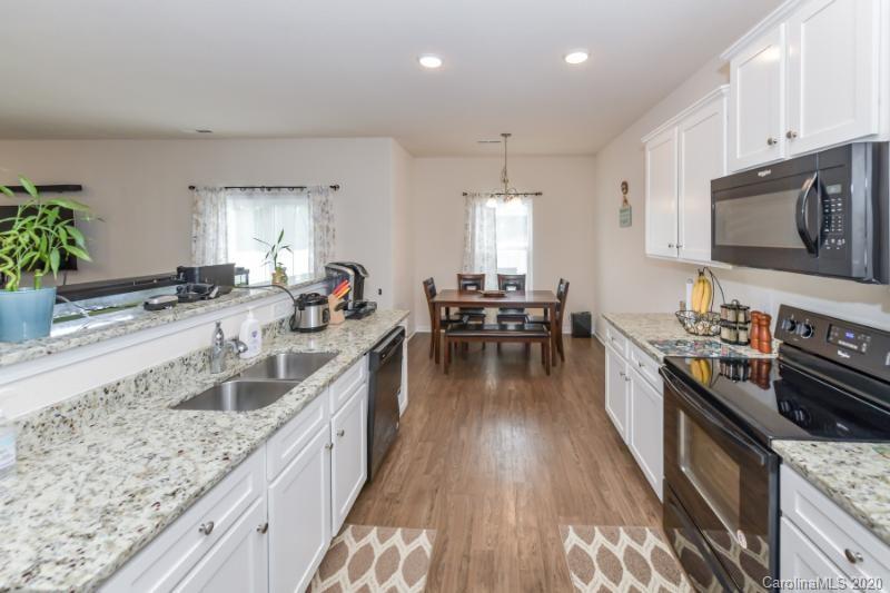 6565 Paw Village Road Charlotte, NC 28214 - Photo 7 of 26 a kitchen with stainless steel appliances granite countertop a sink stove and refrigerator