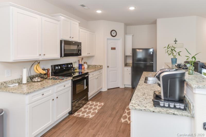 6565 Paw Village Road Charlotte, NC 28214 - Photo 8 of 26 a kitchen with kitchen island granite countertop a sink a stove and refrigerator